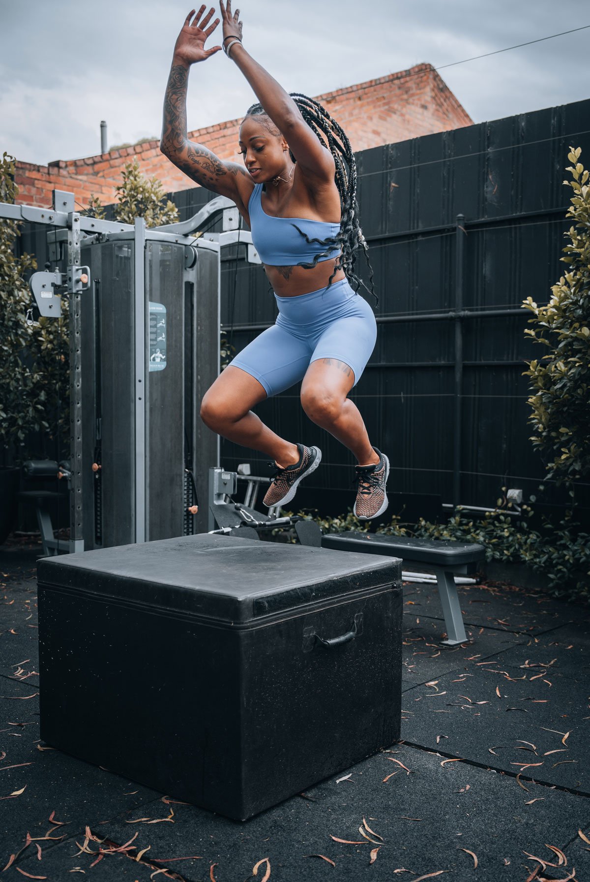 Coach is jumping on a block wearing blue workout outfit.